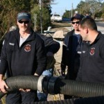 Firefighter/Paramedics Tim Rebholz and Robert Koenig move a rigid intake hose into position at Spring Lake in Destin.