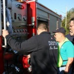 Chief Brown describes the pump operations to the students at the Engine 9 pump panel.