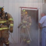 An exhausted crew exits the building at the completion of their evolutions as Battalion Chief Dennis Lawson looks on.